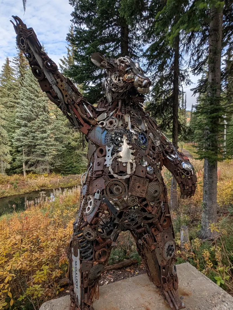 Metal bear sculpture beside a village trail
