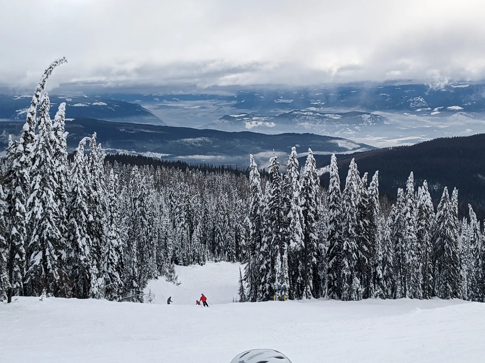 A wide snowy run with views over the valley